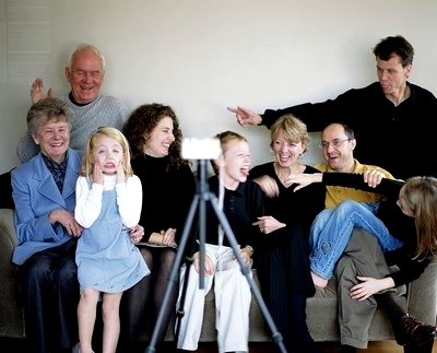 Neuf personnes, hommes, femmes et enfants posent pour une photo devant un téléphone portable
