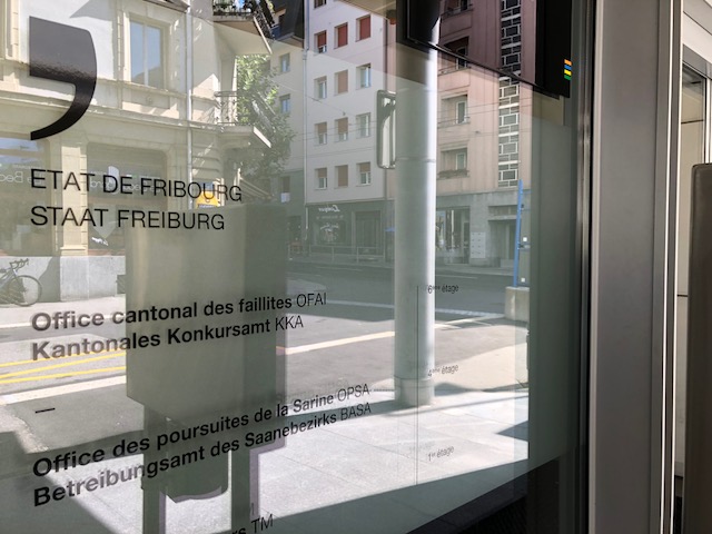 Une plaque indique l'entrée de l'office cantonal des faillites et des poursuites de la Sarine
