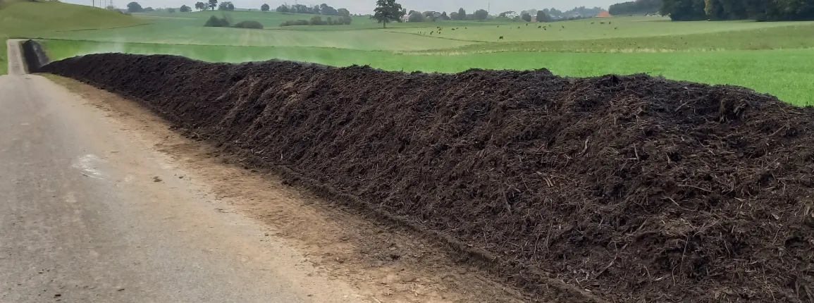 Compostage en bord de champ : la décomposition contrôlée de matières organiques par des microorganismes génère de la chaleur et transforme les résidus en un amendement riche en humus.
