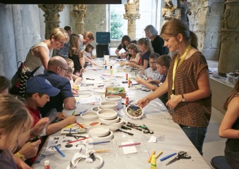 Des femmes. des hommes et des enfants autour d'une table au MAHF