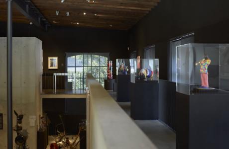 Plusieurs oeuvres exposées dans une pièce de l'espace Jean Tinguely, Niki-de-Saint-Phalle