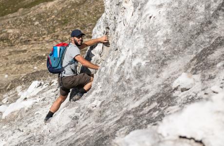 Participant escaladant une falaise de gypse dans le haut vallon de Réchy