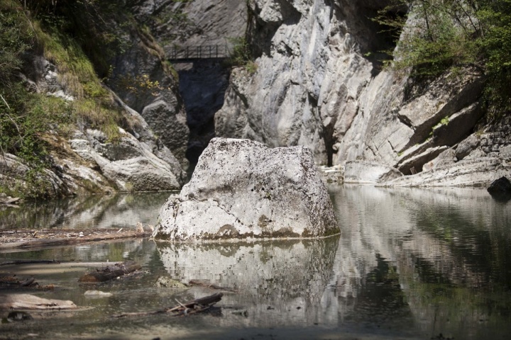 Bild vergrößern Ein Fels im Wasser mit kleiner Brücke im Hintergrund