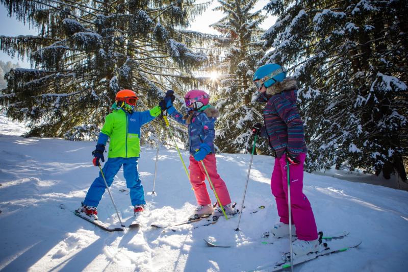 Enfants en tenue de ski sur une piste enneigée