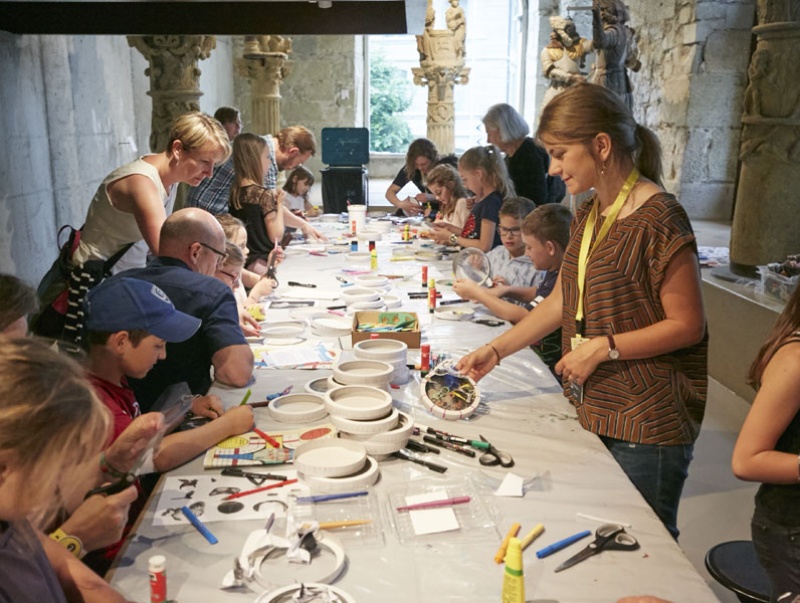 Des femmes. des hommes et des enfants autour d'une table au MAHF