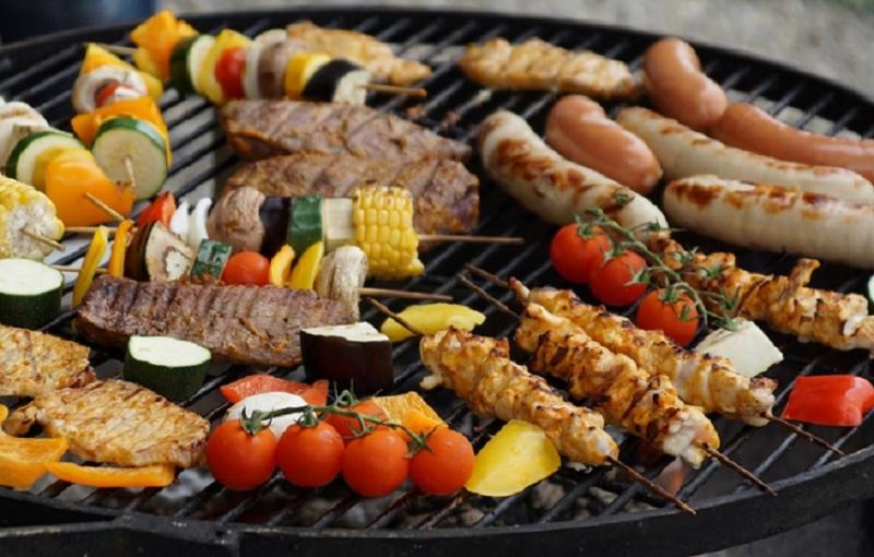 Photo représentant des légumes et de la viande sur un grill