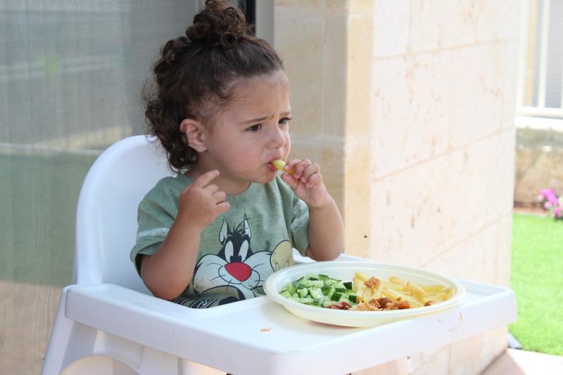 L'image montre une fillette en train de manger